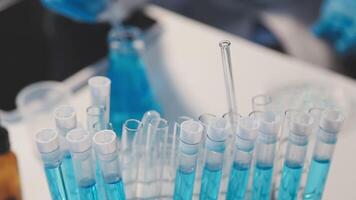Close-up of a scientist's hands holding a flask with pink liquid in a lab. video