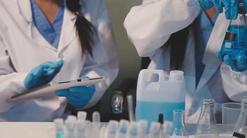 Close-up of a scientist's hands holding a flask with pink liquid in a lab. video