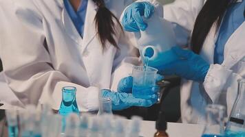 Close-up of a scientist's hands holding a flask with pink liquid in a lab. video