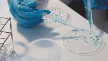 Close-up of a scientist's hands holding a flask with pink liquid in a lab. video