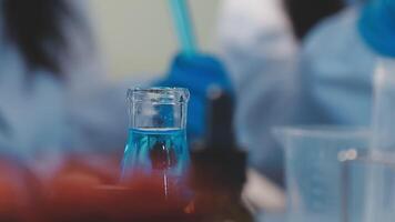 Close-up of a scientist's hands holding a flask with pink liquid in a lab. video
