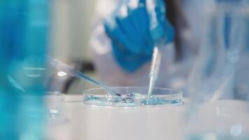 Close-up of a scientist's hands holding a flask with pink liquid in a lab. video