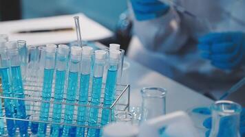 Close-up of a scientist's hands holding a flask with pink liquid in a lab. video