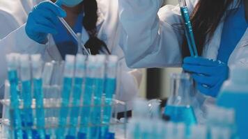 Close-up of a scientist's hands holding a flask with pink liquid in a lab. video