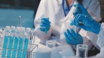 Close-up of a scientist's hands holding a flask with pink liquid in a lab. video