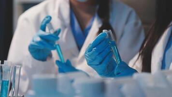Close-up of a scientist's hands holding a flask with pink liquid in a lab. video
