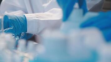 Close-up of a scientist's hands holding a flask with pink liquid in a lab. video