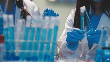 Close-up of a scientist's hands holding a flask with pink liquid in a lab. video