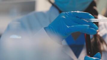 Close-up of a scientist's hands holding a flask with pink liquid in a lab. video