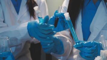 Close-up of a scientist's hands holding a flask with pink liquid in a lab. video