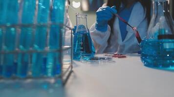 Close-up of a scientist's hands holding a flask with pink liquid in a lab. video
