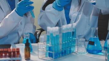 Close-up of a scientist's hands holding a flask with pink liquid in a lab. video