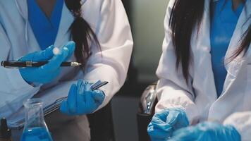 Close-up of a scientist's hands holding a flask with pink liquid in a lab. video