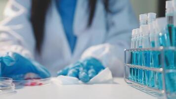 Close-up of a scientist's hands holding a flask with pink liquid in a lab. video