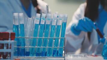 Close-up of a scientist's hands holding a flask with pink liquid in a lab. video