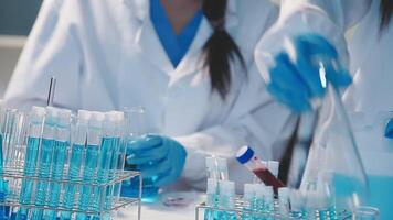 Close-up of a scientist's hands holding a flask with pink liquid in a lab. video