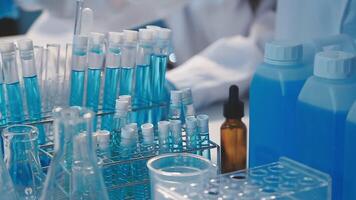 Close-up of a scientist's hands holding a flask with pink liquid in a lab. video