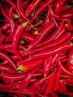 Red hot chilli peppers pattern texture background. Close up. Landscape. A backdrop of Red hot chilli peppers. Vegetable market. Group of Red hot chilli peppers photo