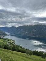 A vast expanse of water enclosed by towering mountains on a overcast day photo