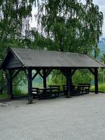 A shelter with tables underneath in a gravel area under the sky photo
