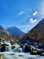 A beautiful mountain river under a clear blue sky with a scenic view of the valley photo