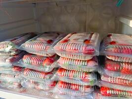 Strawberries from local market, Fresh strawberries picked from home garden in a tray, Red ripe strawberries in plastic tray and packed in clear plastic bag for sale photo