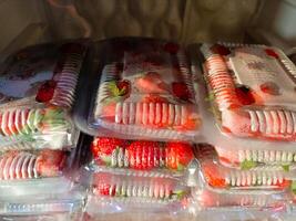 Strawberries from local market, Fresh strawberries picked from home garden in a tray, Red ripe strawberries in plastic tray and packed in clear plastic bag for sale photo