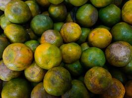 Stacks of orange fruits that look very fresh with a tasteful color at market outdoor photo