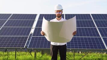 An engineer checks the design documentation of the solar station video