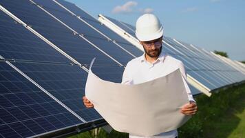 An engineer checks the design documentation of the solar station video