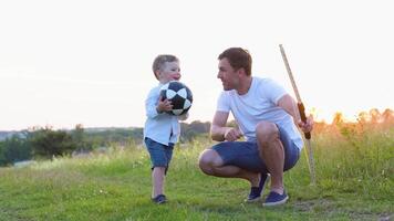 Father teaching son to use bow and arrow. Happy dad and baby son play together with bow and arrow video