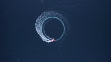 Luxury boat forms a circle of waves with its engines over the sparkling video