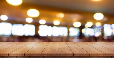 Empty wooden table top with lights bokeh on blur restaurant background. photo