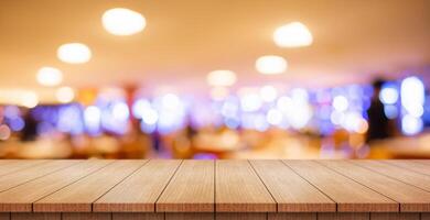 Empty wooden table top with lights bokeh on blur restaurant background. photo