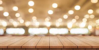 Empty wooden table top with lights bokeh on blur restaurant background. photo