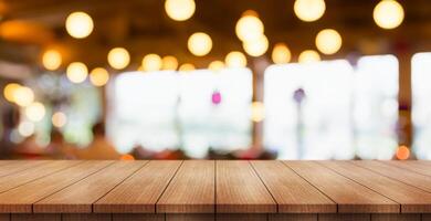 Empty wooden table top with lights bokeh on blur restaurant background. photo