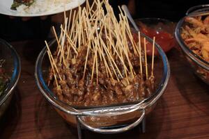 Delicious and tasty meat satay served in a glass tray photo
