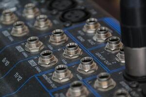 row of silver gold audio input connectors, on a professional audio mixing console or desk photo