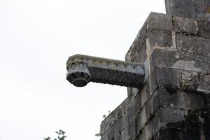 Old stone gargoyle extending out from building in europe photo