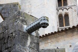 Old stone gargoyle extending out from building in europe photo