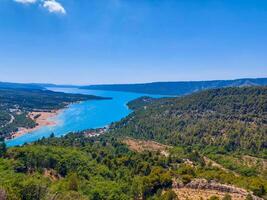 magnificent lake of Sainte-Croix with clear crystalline waters, incredible view of blue waters where you can sunbathe, do sports such as canoeing, lake surrounded by nature, trees, rocks. Sunny day photo