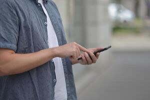 A man on the street using a smartphone. Mobile phone in hands close-up. photo