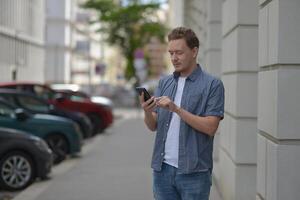 A man on the street using a smartphone. Concept of communication in social networks and messengers. photo