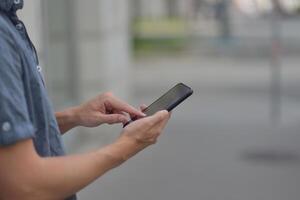 A man on the street using a smartphone. Mobile phone in hands close-up. photo