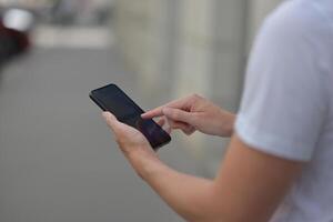 A man on the street using a smartphone. Mobile phone in hands close-up. photo