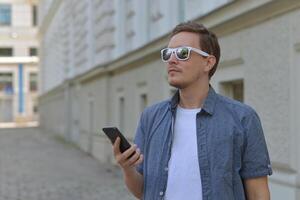 A man on the street using a smartphone. Concept of navigating in the city and using mobile maps. photo