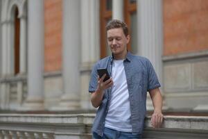 A man on the street using a smartphone. Concept of communication in social networks and messengers. photo