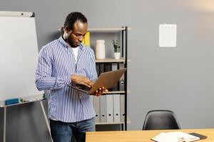 Man typing on laptop computer photo