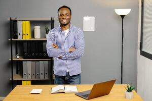 Man standing in front of desk with laptop photo