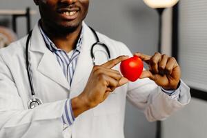 Man in white lab coat holding red heart photo